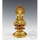 A gilt metal figure of a Bodhisattva seated upon a lotus throne, modelled in the mudra position,