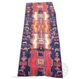 A Caucasian wool runner, worked with an Aztec style design against a deep blue ground,