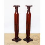A pair of Edwardian inlaid mahogany jardiniere stands, formerly bed posts,