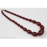 A cherry amber graduated bead necklace, designed as twenty seven graduated plain polished beads,