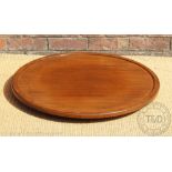 A walnut lazy Susan of large proportions, the circular top with a moulded edge,