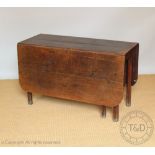 A George III oak drop leaf table, on tapered legs,