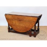 An early 18th century oak gate leg table, with moulded detailing, on turned and block legs,