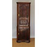 A George III and later oak standing corner cabinet, with two panelled doors, on ogee bracket feet,