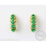 A pair of emerald and diamond earrings, designed as a vertical drop of five emeralds,