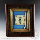 A 17th century Delft tile decorated with blue floral sprays in a vase, and pipe,