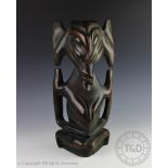 A large African carved wood figure of fertitlilty modelled kneeling,