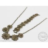 A filigree necklace and matching bracelet, designed as wire work flower heads,