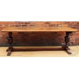 An 18th century style carved oak refectory type table, the six plank top with cleated ends,