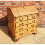 An 18th century and later walnut bureau, with fall enclosing a fitted oak and walnut interior,