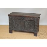 An early 18th century oak coffer, the double panelled front with later carved detailing,