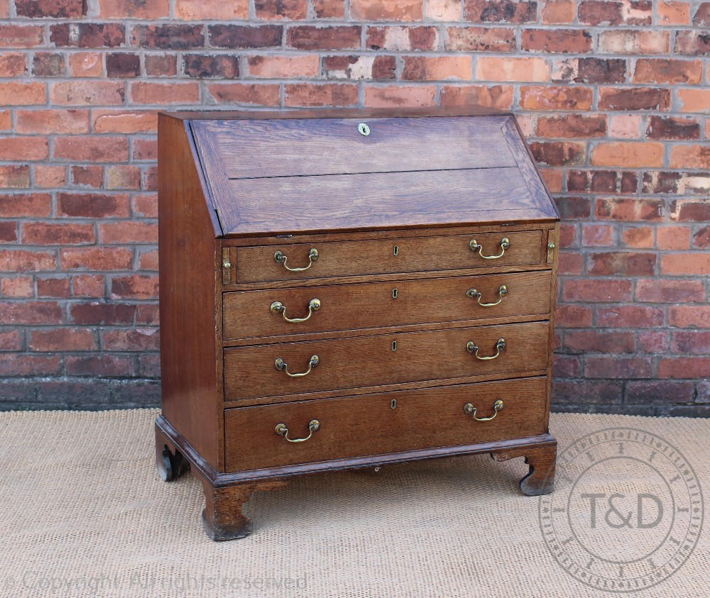 A George III oak bureau, with fall enclosing a fitted interior, above four graduated long drawers,