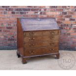 A George III oak bureau, with fall enclosing a fitted interior, above four graduated long drawers,