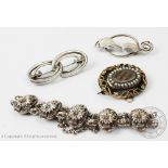 A silver bracelet, designed as ten oval floral links, with integral clasp and attached safety chain,