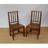 A pair of George III provincial oak dining chairs, with moulded bar backs and solid seats,