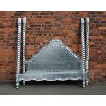 A modern silver coloured four poster bed,