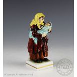 An early 20th century German porcelain figure of a peasant and child, inscribed to underside '9604',