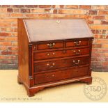 A George III oak and mahogany cross banded bureau, with fall enclosing a fitted interior,