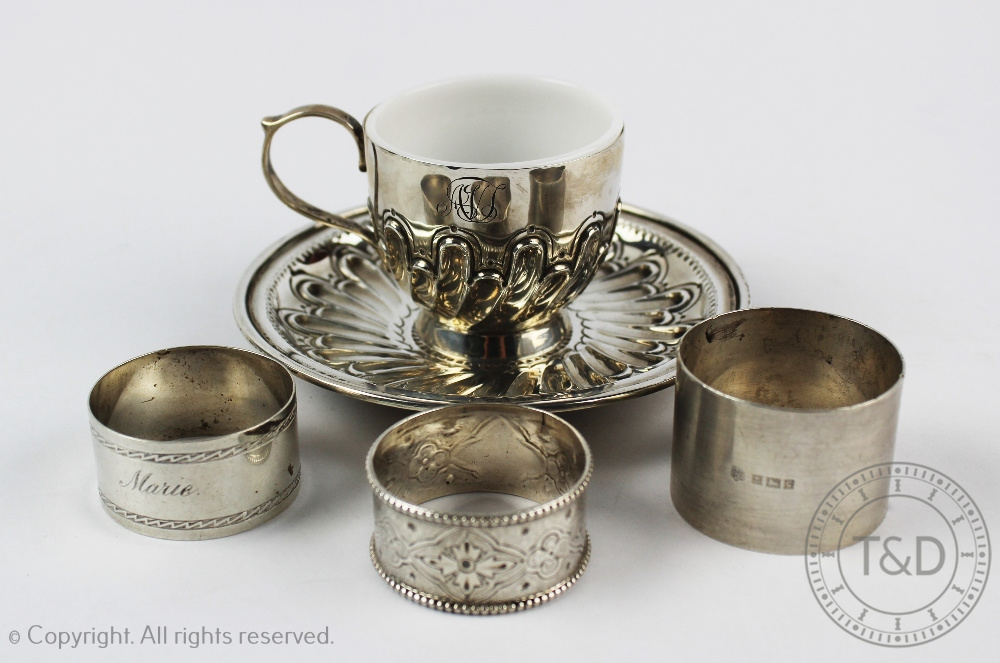 A Victorian silver tea cup and saucer, London 1896, the cup with milk glass liner,