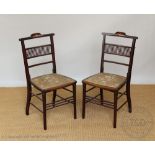 A set of four stained beech ladder back chairs, with rush seats, on tapered legs,