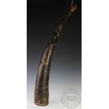 An African carved and stained ivory and stitched animal hide mounted instrument / oliphant horn,