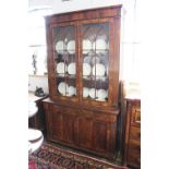 A Regency mahogany bookcase, with two arched astragal glazed doors enclosing shelves,