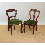 A set of four Victorian carved walnut dining chairs, with turned backs and green upholstered seats,