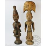 Two West African carved wood Yoruba type figures, both modelled kneeling,