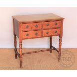 An Edwardian light oak side table, with four short drawers, on turned legs,