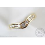 A diamond set ring, of shaped form and set with nine graduated brilliant cut diamonds,