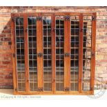 An Arts and Crafts style oak bookcase, with six lead glazed doors, the bookcase has an open back,