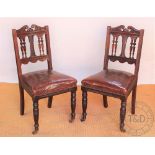 A set of six late Victorian carved walnut dining chairs, with leather seats, on turned legs,