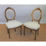 A pair of Louis XVI style gilt beech side chairs, with oval backs and padded seats,