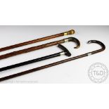 Three late Victorian silver mounted walking canes, comprising,