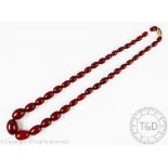 A single strand, graduated cherry amber necklace, designed as thirty nine graduated beads,