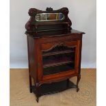 A Victorian carved mahogany display cabinet, with glazed door, above an under tier, on scroll legs,