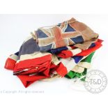 A vintage linen Red Ensign flag, stitched in section, 45cm x 91cm, with six linen Union Flags,