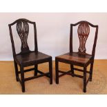 A set of four George III oak country kitchen chairs, with pierced splats and solid seats,