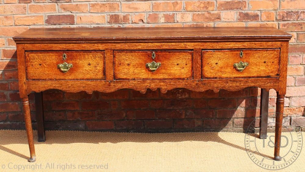 An 18th century Shropshire oak dresser base, with three drawers above a serpentine apron,