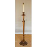 A gold painted standard lamp, modelled as an altar stick,