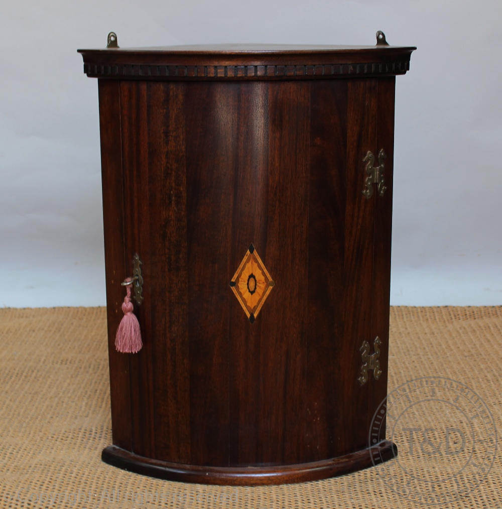 A George III style inlaid bow front corner cabinet,