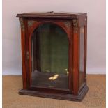 A Victorian walnut display cabinet, with beveled glass arched door flanked by caryatid masks,