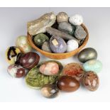 A selection of polished hard stone and marble eggs, some with name labels,