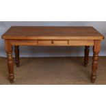 A modern farmhouse style pine table, with drawer, on turned and block legs,