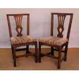 A set of four George III country oak dining chairs,