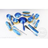 A collection of fourteen silver and blue enamel brushes to include; hand mirrors, a comb,