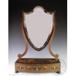 A 19th century Sheraton style painted toilet mirror, with shield shaped mirror on a serpentine base,