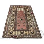 A Turkish Milas wool rug/ prayer mat, worked with geometric designs,