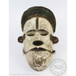 A West African Nigerian Ogoni mask, carved and painted wood, with articulated jaw,