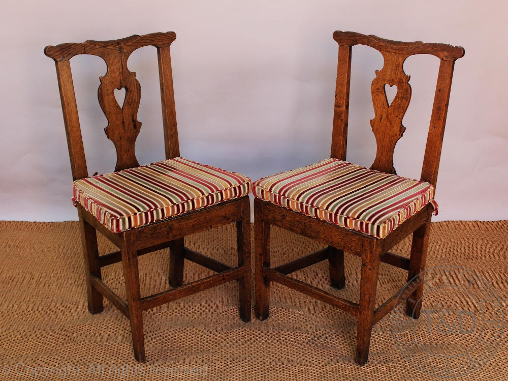 A set of four George III country oak dining chairs,